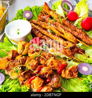 Szaszlyk alla griglia e riares di carne con insalata verde Foto Stock