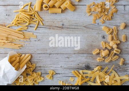 diversi tipi di tagliatelle all'uovo e pasta gialla su sfondo di legno Foto Stock