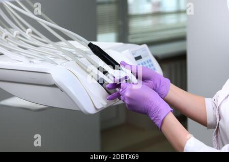 Un infermiere in guanti pulisce gli strumenti dentali . Foto irriconoscibile. Solo mano. Disinfezione in odontoiatria. Spazio di copia. Foto Stock