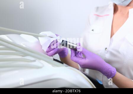 Disinfezione nell'ufficio odontoiatrico. Un'infermiera pulisce gli strumenti dentali.una foto irriconoscibile.il concetto di salute. Spazio di copia. Foto Stock