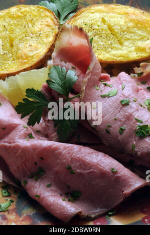 Arrosto di manzo con patate arrosto e limone Foto Stock