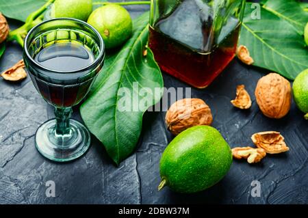 Liquore fatto di noci o noci cracker. Nocino in bicchiere, liquore italiano Foto Stock