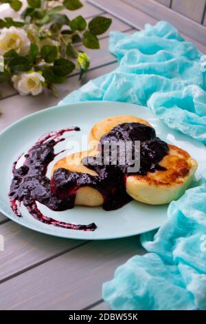 Frittelle di formaggio cottage con curry e marmellata di bolle su piatto di tè vintage, immagine verticale Foto Stock