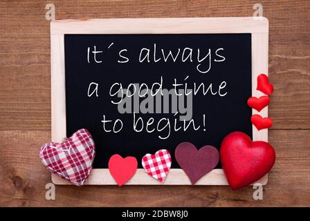 Balckboard con citazione in inglese è sempre un buon momento per iniziare. Decorazione del cuore rosso. Marrone legno sfondo Foto Stock