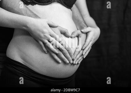 coppia incinta innamorato del ventre del bambino. Mani sullo stomaco bambino bump. Marito mano incinta pancia Foto Stock