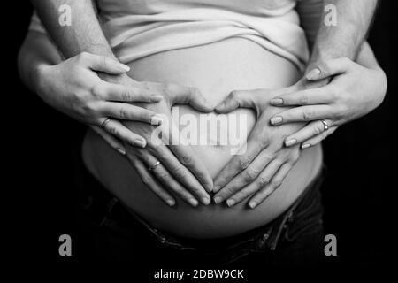 coppia incinta innamorato del ventre del bambino. Mani sullo stomaco bambino bump. Marito mano incinta pancia Foto Stock