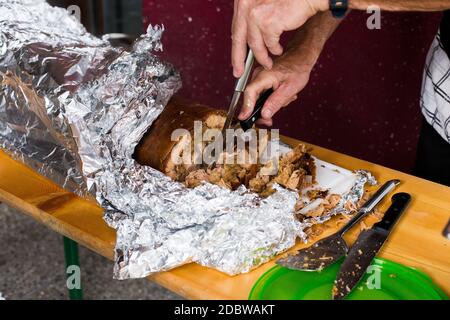 Maialino alla griglia / suzione, con la pelle ancora su di esso avvolto in lamina di alluminio. Foto Stock