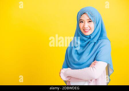 Arabo musulmano asiatico, Ritratto di felice bella giovane donna islamica religiosa indossare velo hijab lei sorridente stand braccio incrociato, studio girato isolato su di voi Foto Stock