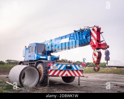 La gru per cantieri sta sollevando un cartello a LED vuoto su sfondo blu cielo per la nuova pubblicità Foto Stock