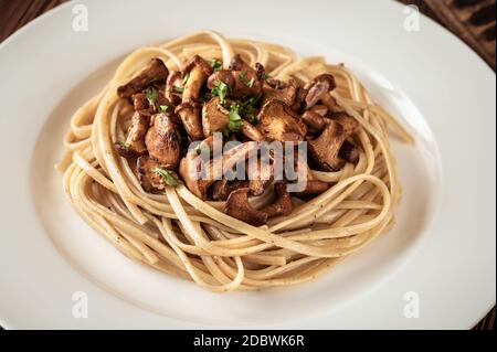 Porzione di pasta linguina con finferli fritti Foto Stock