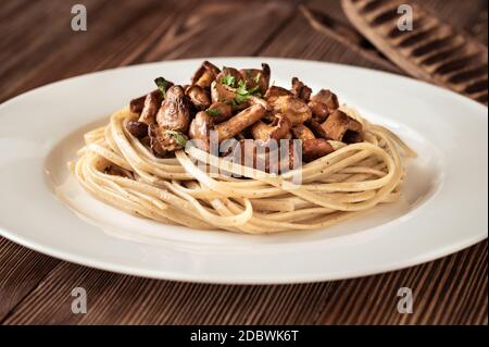 Porzione di pasta linguina con finferli fritti Foto Stock