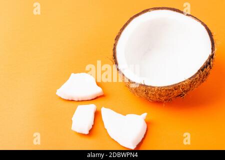 Happy Coconuts giorno concetto, fresco gruppo di cocco impostare diverse metà e fette, studio girato isolato su sfondo arancione Foto Stock