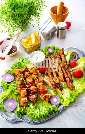 Szaszlyk alla griglia e riares di carne con insalata verde Foto Stock