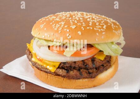 Un doppio cheeseburger con lattuga, sottaceti, pomodori e un panino di semi di sesamo Foto Stock