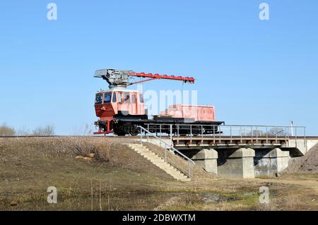 Gru ferroviaria rossa sul ponte in campagna Foto Stock