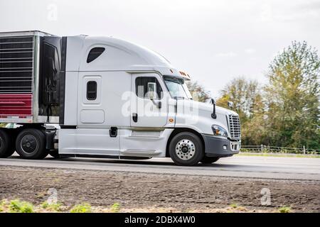 Lato del cofano potente carro bianco grande a lunga percorrenza industriale semirimorchio di grado con unità frigorifero sulla semirimorchio refrigerata rimorchio in esecuzione sull'hig Foto Stock