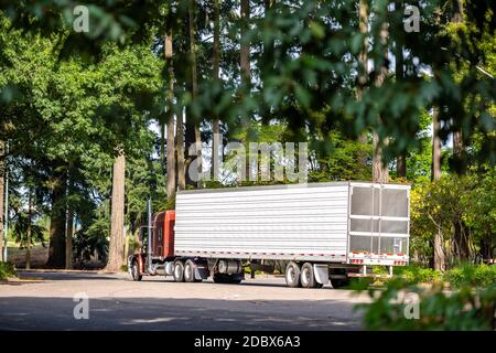Trattore industriale semi-camion marrone Big RIG con frigorifero carico il semirimorchio trasporta gli alimenti surgelati per la consegna e il funzionamento il parcheggio dell'area di riposo Foto Stock