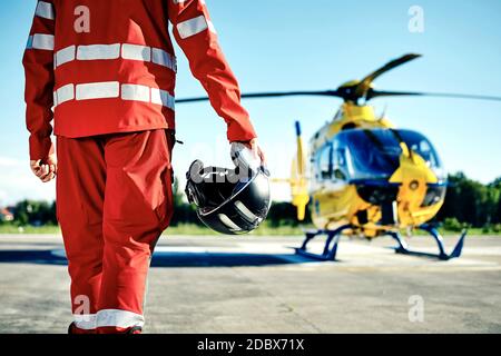 Allarme per elicottero il servizio di emergenza medica. Paramedic in esecuzione su un elicottero su un eliporto. Temi di salvataggio, aiuto e speranza. Foto Stock