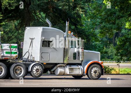 Trattore semi-camion industriale Classic bianco per trasporto lungo Big RIG con vano sleeper cab per il supporto conducente del veicolo e carico letto piatto semi rimorchio st Foto Stock