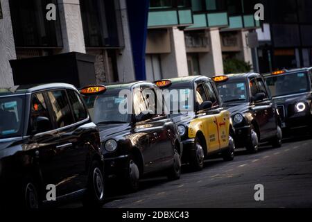Una coda di taxi neri fuori Victoria Station, Londra. I tassisti di Londra devono affrontare lunghe attese per una tariffa unica dopo che il settore ha visto un forte calo della domanda, in quanto le restrizioni del coronavirus continuano a ridurre i viaggi e il lavoro in ufficio. Foto Stock