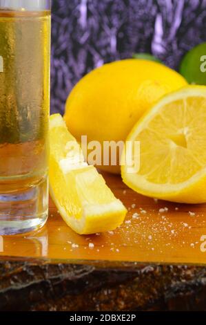 Una composizione verticale di un colpo di tequila pronto con limone tagliato fresco. Foto Stock