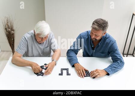 Anziano anziano anziano che gioca gioco da tavolo Domino Foto Stock