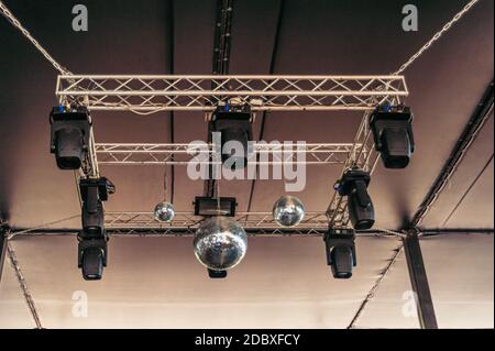 Diverse palle da discoteca e luci stroboscopiche appendono dal soffitto del nightclub Foto Stock