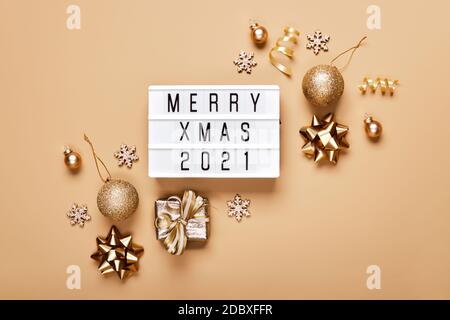 Lightbox con testo ALLEGRO XMAS 2021 e decorazione dorata di natale su sfondo beige. Layout creativo in colori monocromatici neutri Foto Stock