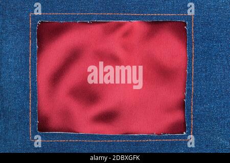 Telaio realizzato in tessuto denim con cuciture gialle su seta rossa, con spazio per il testo Foto Stock