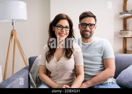 Happy Couple Family indossare occhiali da vista sul divano Foto Stock