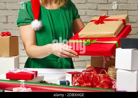 Mani femminili che tengono presente imballato per natale sfondo festivo per le feste compleanno, giorno di San Valentino, Natale, Capodanno. Concetto di servizio di imballaggio Foto Stock