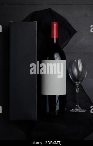 Una bottiglia di vino su un tavolo di legno nero da vista dall'alto con tappo rosso Foto Stock