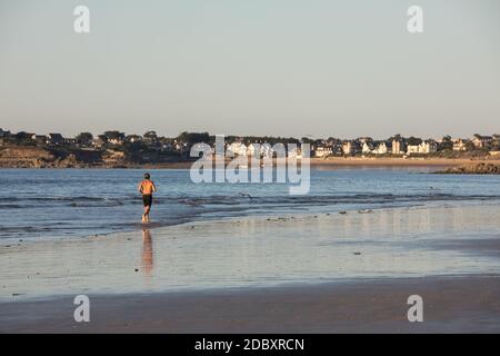 Saint Malo, Francia - 16 Settembre 2018: l uomo è in esecuzione lungo la spiaggia di Saint Malo, Brittany, Francia Foto Stock