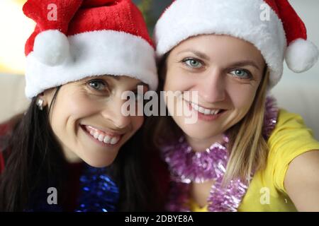 Ritratto di due donne nei cappelli di babbo natale decorazioni a casa Foto Stock