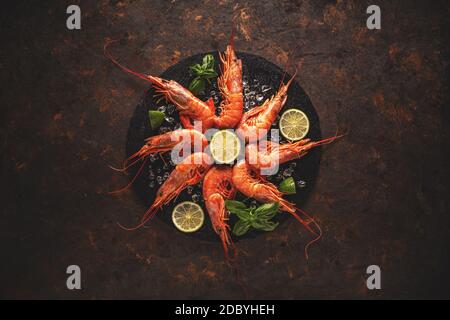 Concetto di cibo di mare, gamberi del re con limone su sfondo grugnoso Foto Stock