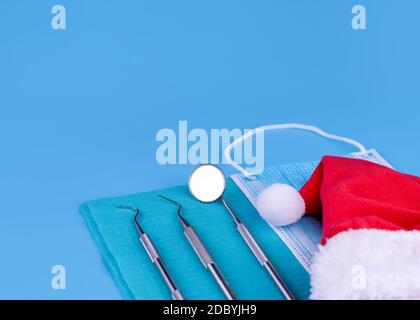 Buon Natale e Felice anno nuovo da Dentist Set di Dental Tools e Babbo Natale su sfondo blu. Foto Stock