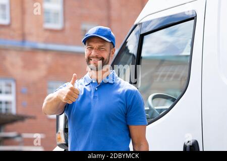 Smiling Delivery uomo o Handycam in uniforme vicino al camion Foto Stock