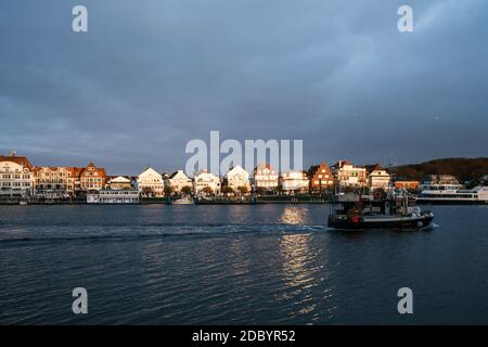 Lo skyline di Lübeck-Travemünde è illuminato dal sole che sorge e il cielo è nuvoloso Foto Stock