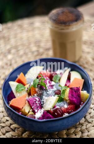 esotica insalata di frutta tropicale asiatica mista con semi di basilico e. cocco in ciotola all'aperto Foto Stock