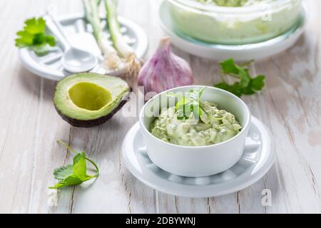 Delizioso avocado spalmato con formaggio di cagliata e ingredienti. Concetto di cibo heathy. Foto Stock