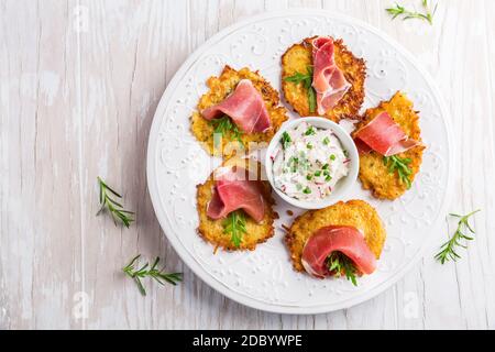 Frittella di patate con prosciutto e salsa di ravanelli, formaggio cremoso e erba cipollina. Concetto di cibo sano. Foto Stock