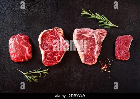 Varietà di bistecche di manzo su sfondo scuro Foto Stock