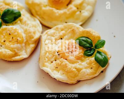 Uova di nuvola soffici. Cibo alla moda - forno cuocere uova strapazzate con albume d'uovo montato e tuorlo intero sul piatto Foto Stock