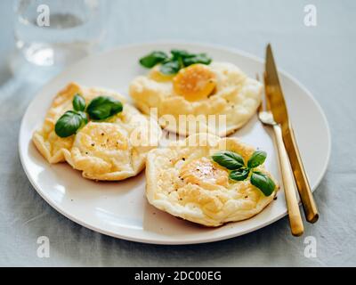 Uova di nuvola soffici. Cibo alla moda - forno cuocere uova strapazzate con albume d'uovo montato e tuorlo intero sul piatto Foto Stock