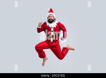 Vacanza migliore. Festa di Natale divertente. Hipster uomo con portatore felice indossare il costume rosso festivo elfo. Salto di babbo natale maturo. Divertente festa invernale. Sentitevi liberi. Felice nuovo 2021 anni. buon natale. Foto Stock