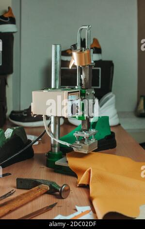Stampa del timbro che fa un timbro su una pelle in officina del calzolaio. Foto Stock