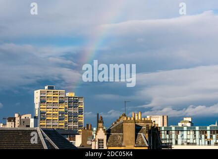 Leith, Edimburgo, Scozia, Regno Unito, 18 novembre 2020. Regno Unito Meteo: Sole con un arcobaleno che appare sopra la cima di un blocco di consiglio casa torre (Coupér Street flats) Foto Stock
