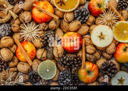 Colorato sfondo di Natale. Cannella, arpili, noci, spezie, fetta d'arancia. Decorazione stagionale. Advent rustico concept.Home fatto natale tavolo festivo. Foto Stock