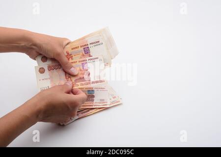 Le mani contano i soldi in un pacchetto di cinque millesimi fatture russe Foto Stock