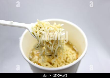 noodle istantanei, zuppa di noodle in una tazza, vista dall'alto. Gli spaghetti istantanei sono venduti in un blocco di spaghetti precotti e secchi, con polvere aromatizzante e/o olio aromatizzante. Foto Stock